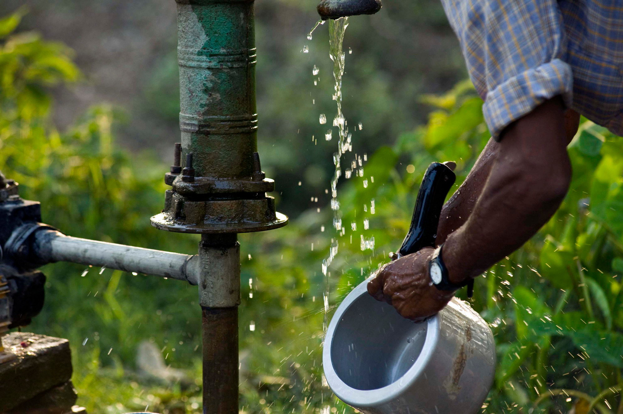 Washing pots and pans, using water drawn from a well - © Simon de TREY-WHITE / WWF-UK Washing pots and pans, using water drawn from a well.