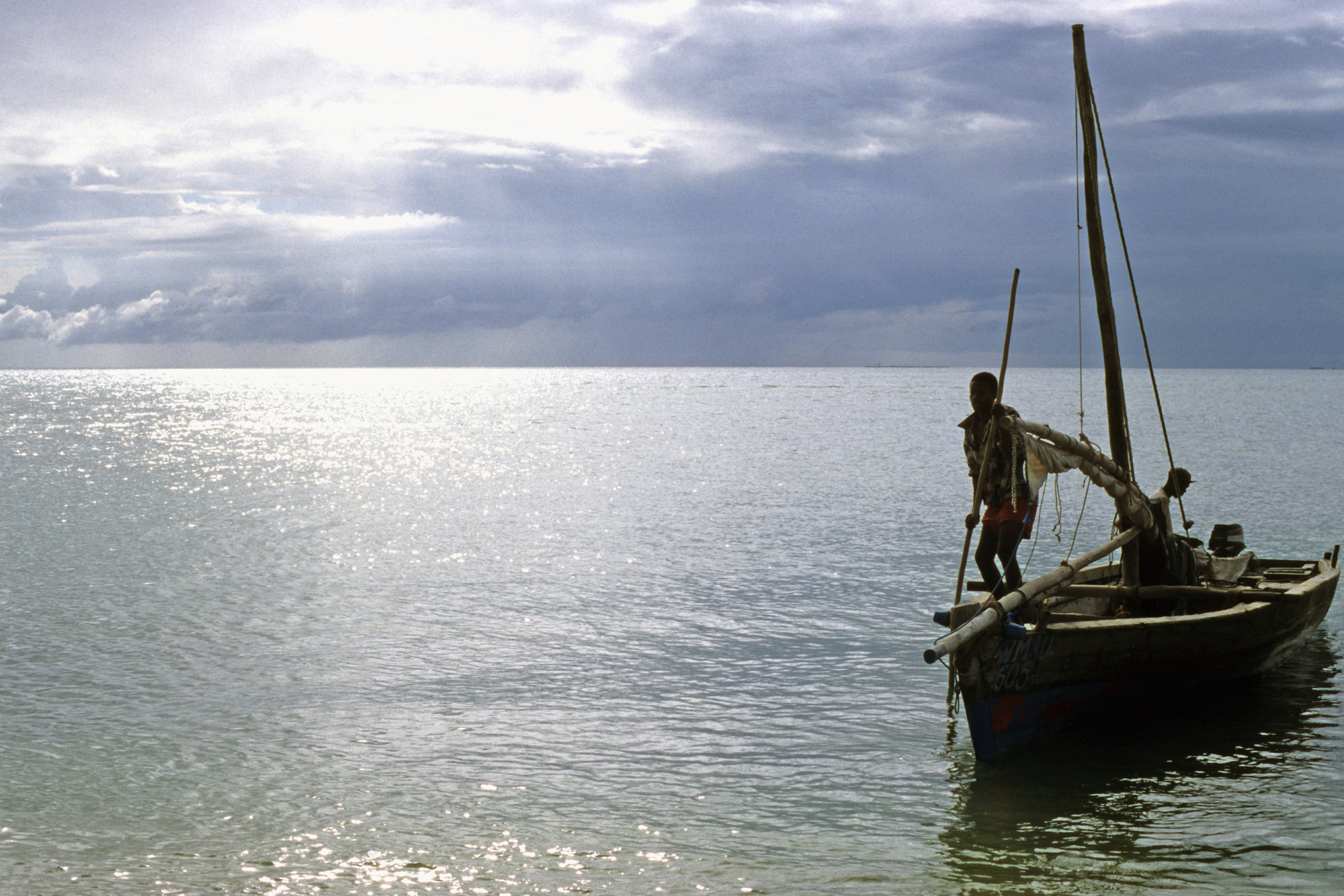 Silhouetted fisherman on a boat waits for a storm to pass. - © WWF-US / Deborah Gainer Silhouetted fisherman on a boat waits for a storm to pass.