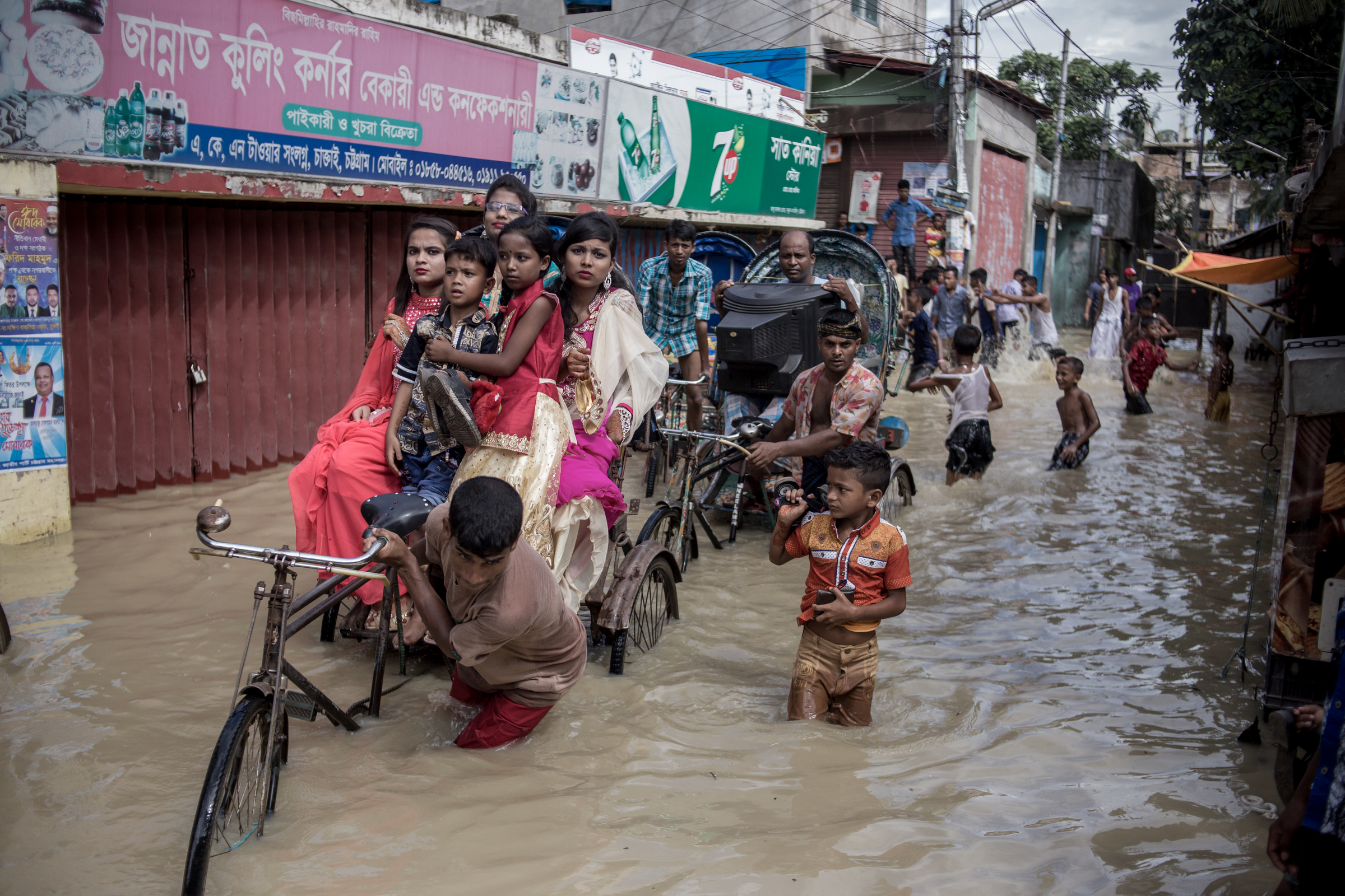 Young people celebrating Eid, a religious festival, travelling by rickshaw during a heavy tidal surge. Young people celebrating Eid, a religious festival, travelling by rickshaw during a heavy tidal surge.