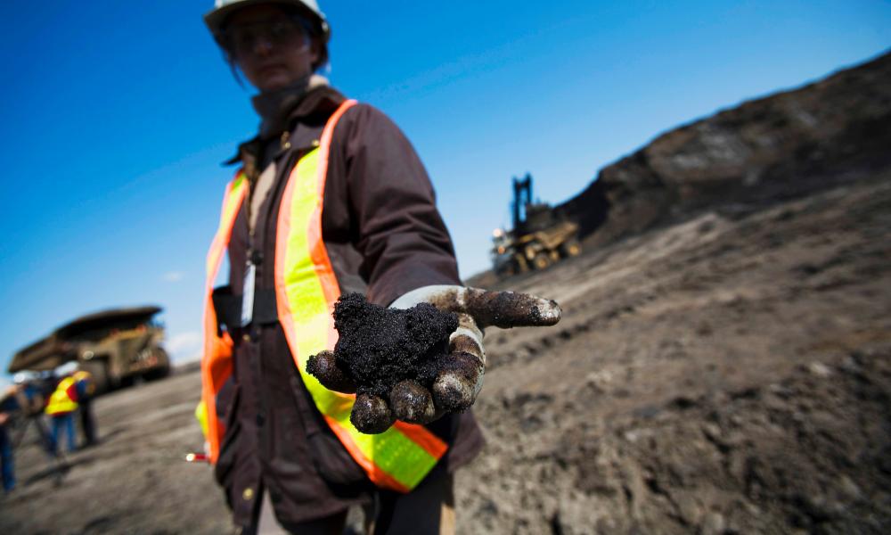 WWF UK staff member Alexandra Hartridge displays oil rich Bitumen sands