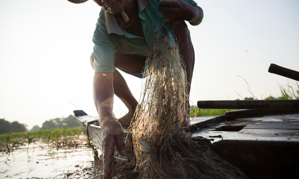 Tran Van Cu pulls a fishing net out of the water. Mekong Thumbnail