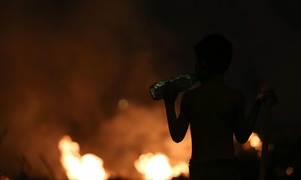 Boy drinks water during Amazon fires