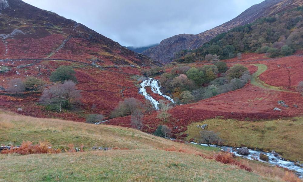 View looking up towards a stream running through a valley in Snowdonia.