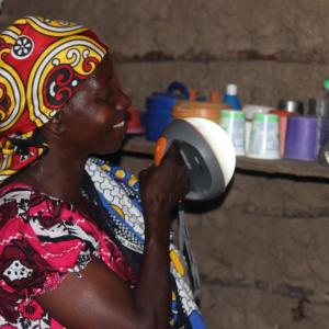 Mama Fatuma using the lantern to light her house