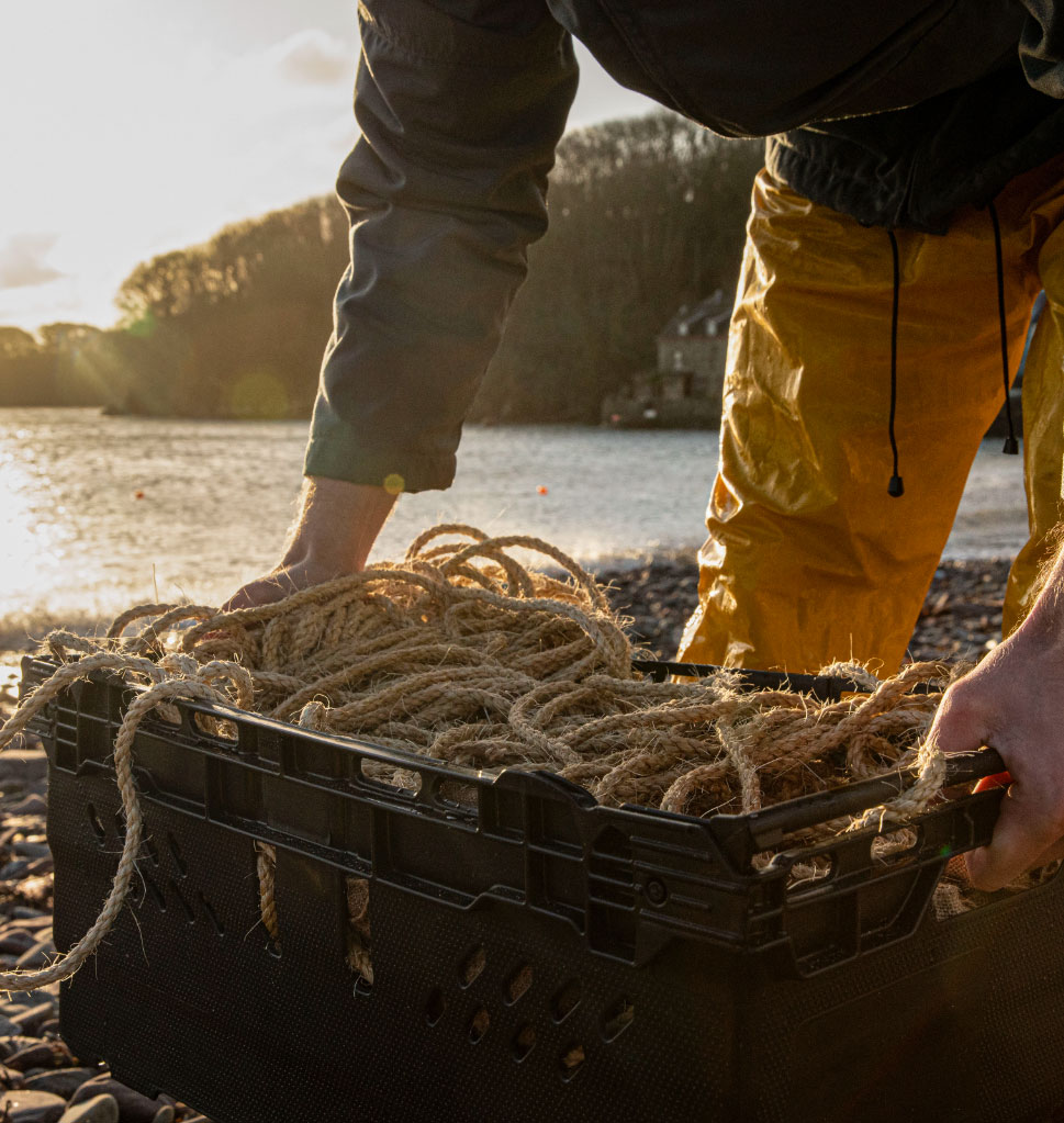 Man picking up a basket of ropes