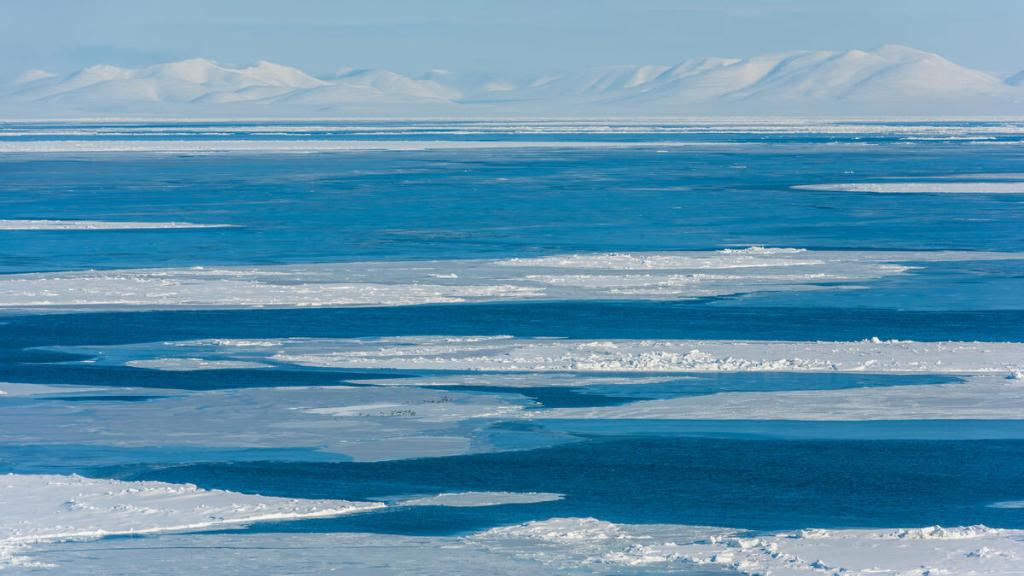 Sea ice in the Bering Strait between Little Diomede (Iŋaliq) and Nome, Alaska, with Seward Peninsula mountains on the horizon