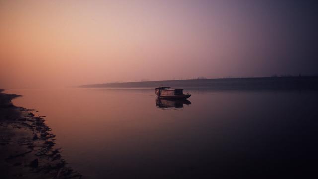 A fishing boat on Dongting Lake at dawn. Hunan Province China.