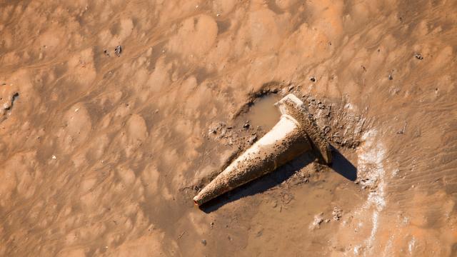 Rubbish thrown into intertidal mud on the side of the river Tees at Middlesbrough, Teeside, UK.