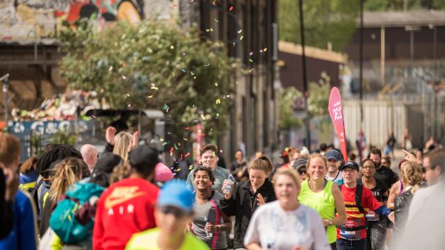 A running race taking part in the street of Hackney, a lot of people are participating