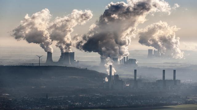 Aerial photo of coal fired power stations Neurath near Grevenbroich and Niederaussem near Bergheim in the Rhenish lignite mining area. Steam coming out of cooling towers. Windturbines near the plant.