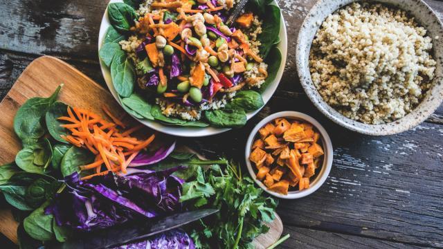 Healthy looking bowl of food including carrots, cabbage, salad leaves and quinoa.