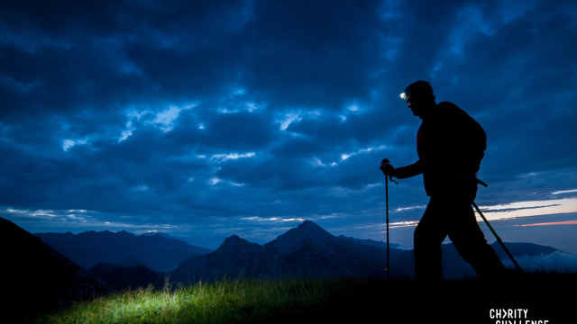 A trekker climbing a mountain at night