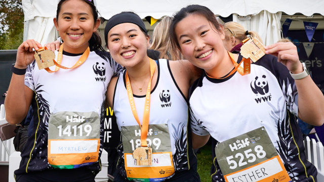 Three WWF runners at the Royal Parks Half Marathon showing their medals