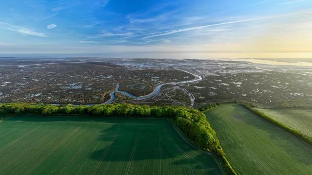 Drone shot of Stiffkey Marshes as tide comes in looking out to ocean. Stiffkey Marshes, Stiffkey, North Norfolk, UK.