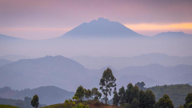 At dusk, mist softens the contours of Mount Muhabura