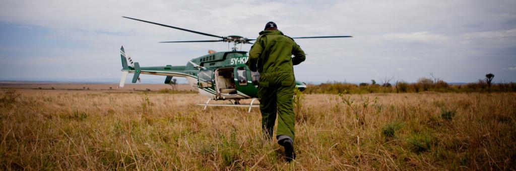 Vets boarding helicopter to go and dart rhinos