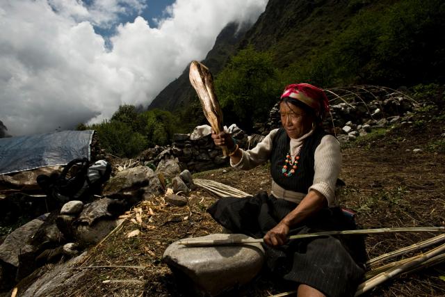 A local woman splitting bamboo