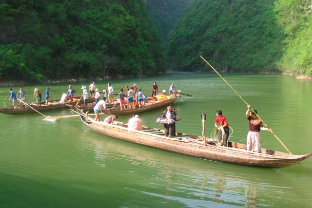 Tujia boatmen steering canoes through a gorge