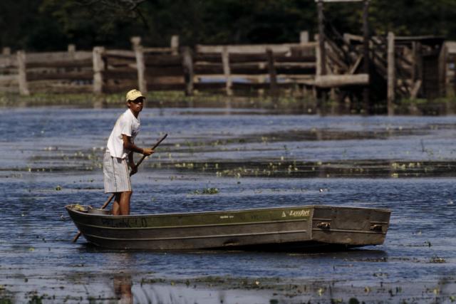 Boy in flat boat , People living in a wetland Mato Grosso , Pantanal, Brazil