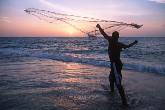 A fisherman casts his fishing net