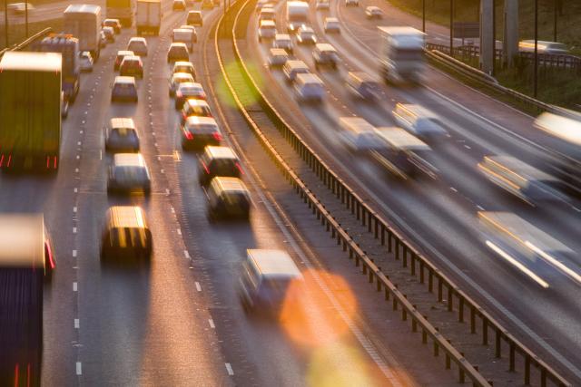 Rush hour traffic on the M60 motorway near Manchester at sunset, UK