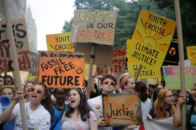 Young people holding placards and marching for climate justice
