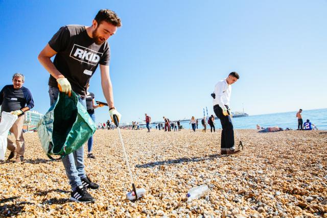 People picking litter on a beach