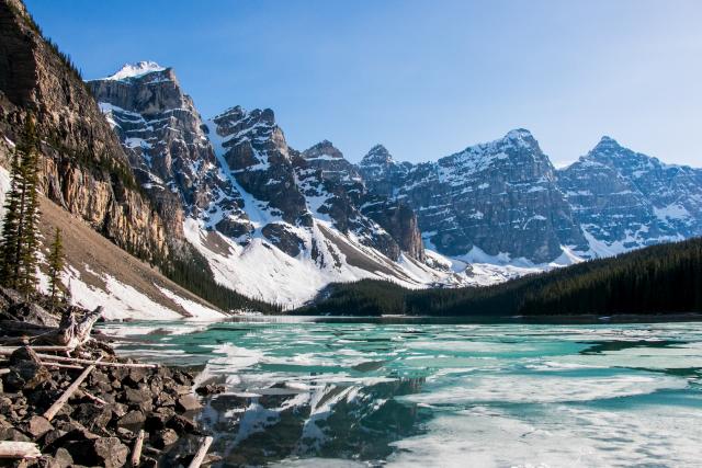 Snow covered mountains by an icy lake. 