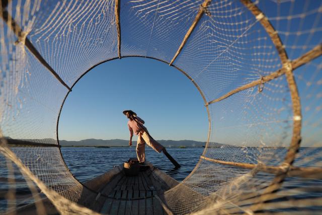 Basket fisherman poses for a frame, Inlay Lake, Myanmar