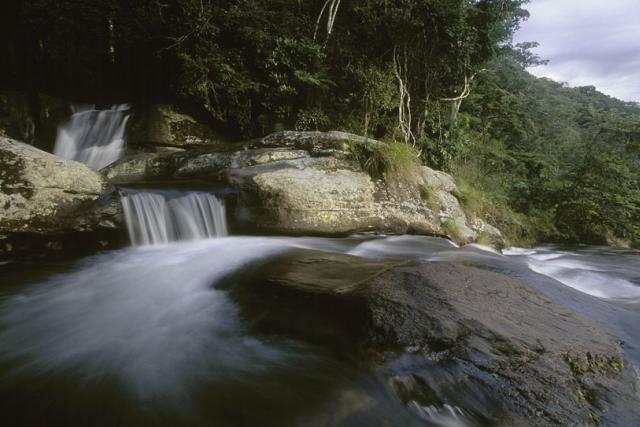 A view from the Sanje waterfall in the Udzungwa Mountains National Park, over sugar cane fields to the Selous Game Reserve, Tanzania