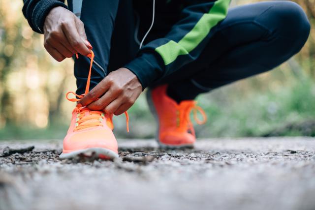 A man lacing his bright orange trainers 