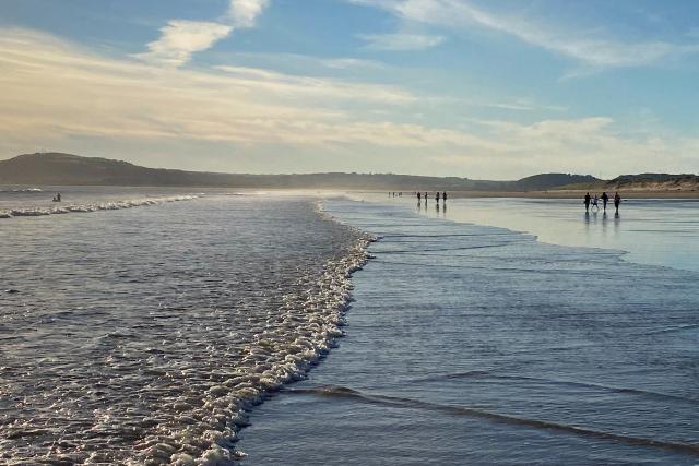An image of groups of people in the distance, walking along a beach