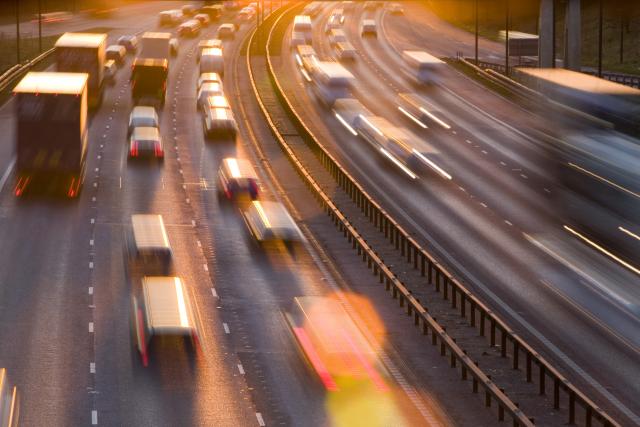 Rush hour traffic on the M60 motorway near Manchester at sunset, UK.