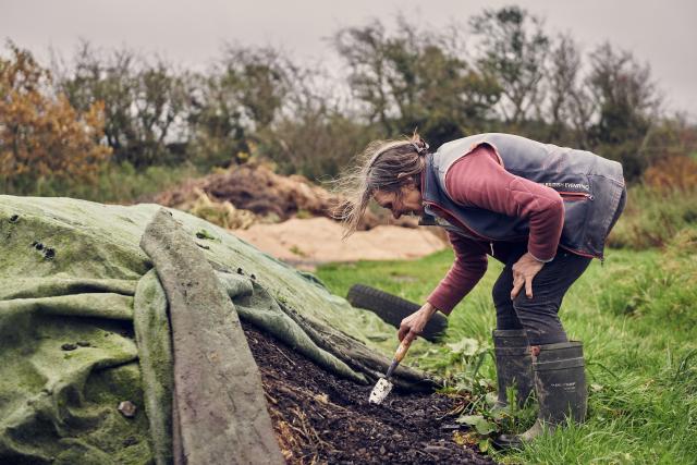 Liz tends to the natural compost created on the farm.