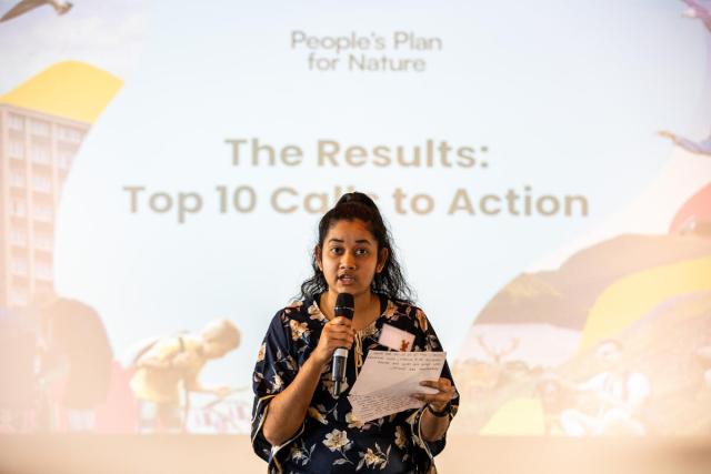 Woman speaking into a microphone at the People’s Assembly for Nature