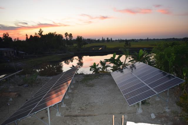 An image of solar panels at sunset