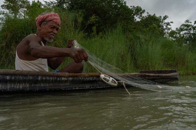 A fisher in a boat deploying the 'pinger'