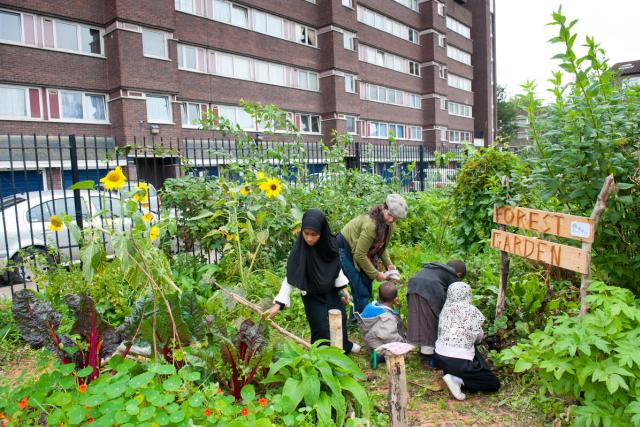 People working and looking around in Evelyn Community Gardens, Deptford, London, England, UK