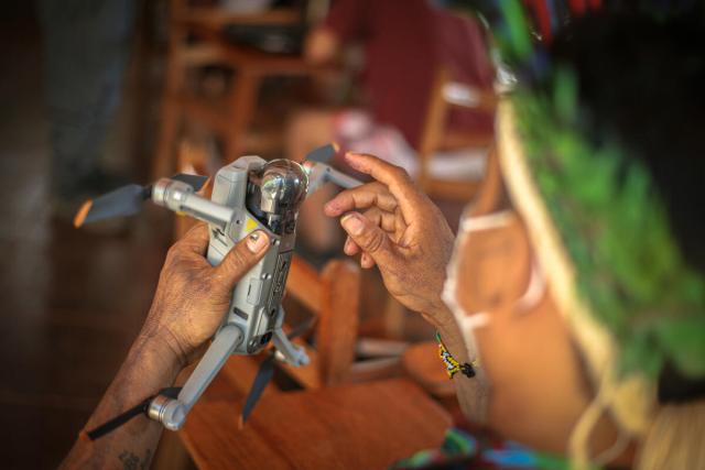 Close up of an Indigenous man holding a drone