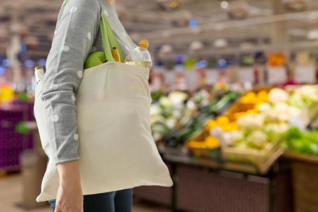 Person carrying shopping bag in supermarket