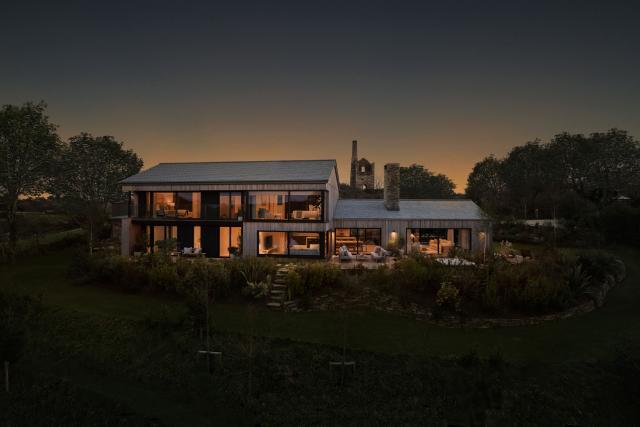 Omaze Cornwall house exterior, outside at night with the sun setting taken at from a raised viewpoint