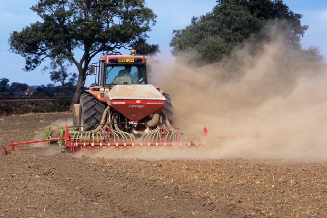 Tractor on farmland during a drought, Warwickshire, UK