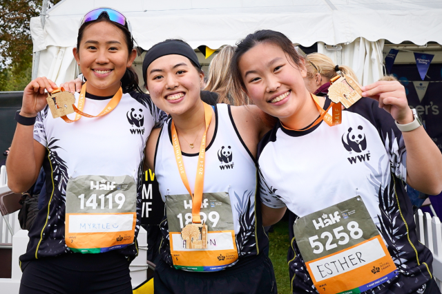 Three WWF runners at the Royal Parks Half Marathon showing their medals