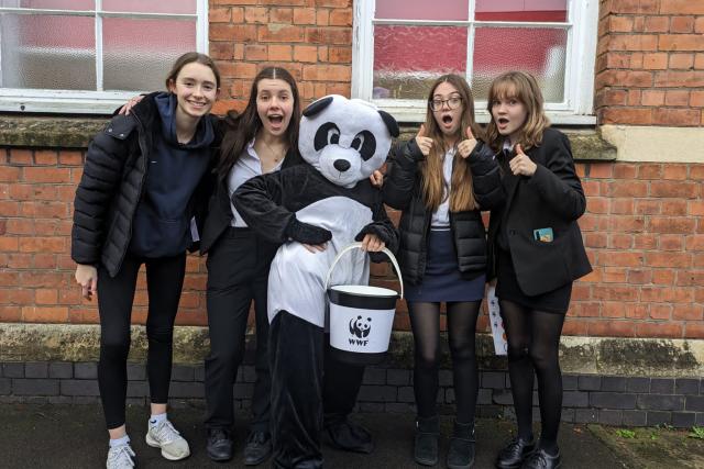 A large group young people, the WWF mascot Chi Chi and a WWF bucket. Fundraising for WWF. 
