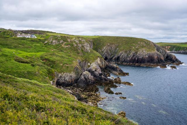 Waves crash against the Pembrokeshire coastline near Câr-Y-Môr seaweed farm in Wales.