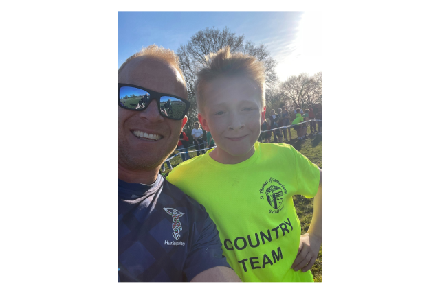 A man in sunglasses and a small boy in a yellow shirt smiling