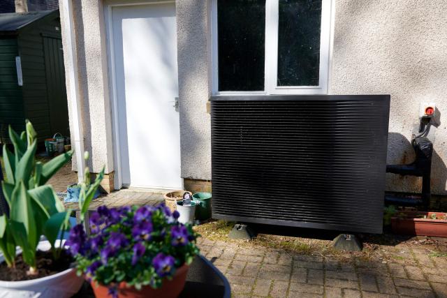 Daikin heat pump with flowers in the forefront of the image