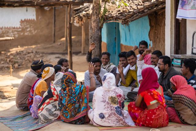 A group of people sat together in a community in India