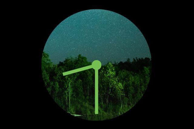 Earth Hour green clock hands on stary night backdrop