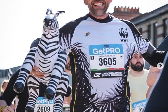 A runners in the bath half marathon in WWF top and holding an inflatable zebra